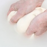 Soaking the dough in water to rinse out the flour.