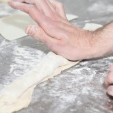 Flip over the edge of the dough and press with palm of your hand to create tension