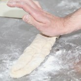 Flip over the edge of the dough and press with palm of your hand to create tension