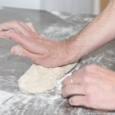 Flip over the edge of the dough and press with palm of your hand to create tension