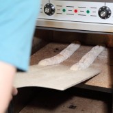 Baguettes transported onto the hot stones of our Rofco oven