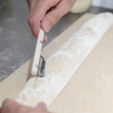 Scoring the baguettes with our lame / bread scoring tool