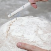 Scoring with the lame / bread scoring tool just before it goes to the oven to bake.