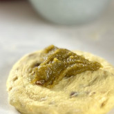 Pistache paste on bun dough, ready to be closed in