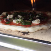 Pizza with grilled aubergines on hot stone in 410C oven