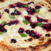 Sweet pizza with crème fraîche lemon curd base, blueberries and white peach and fresh basil
