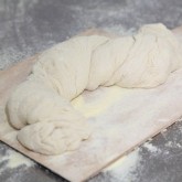 Let it proof on the peel, we cover it with clingfilm to prevent the dough from drying out